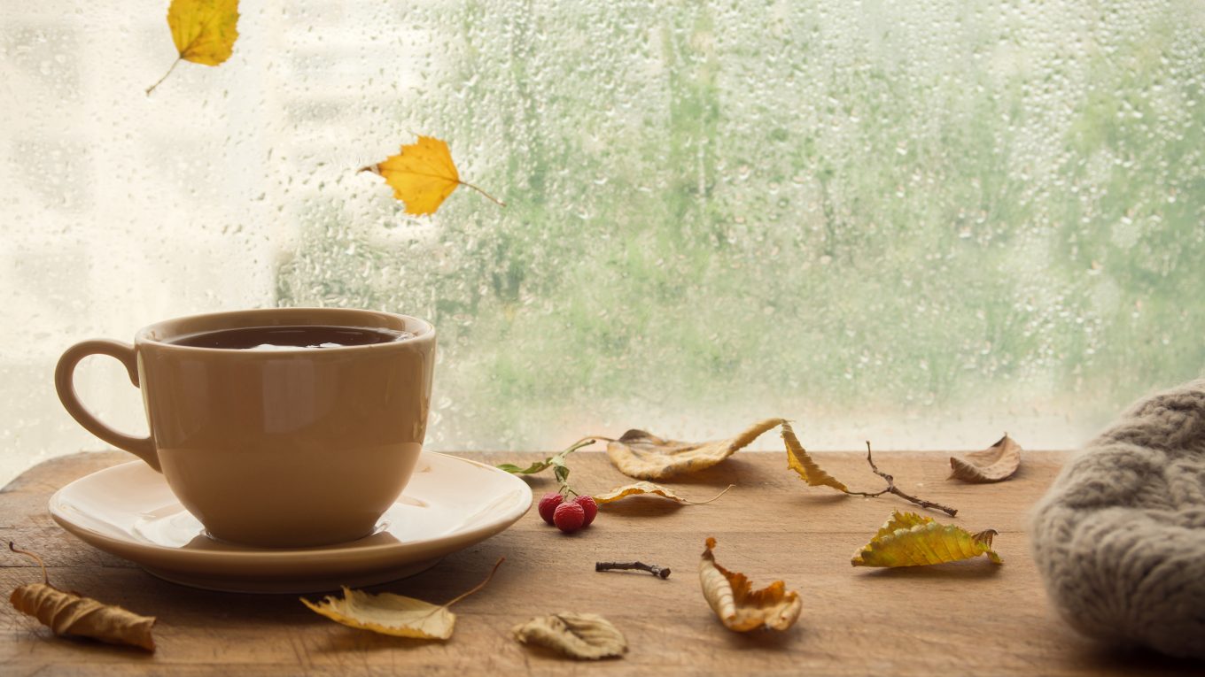 coffee mug with rain on windows in background