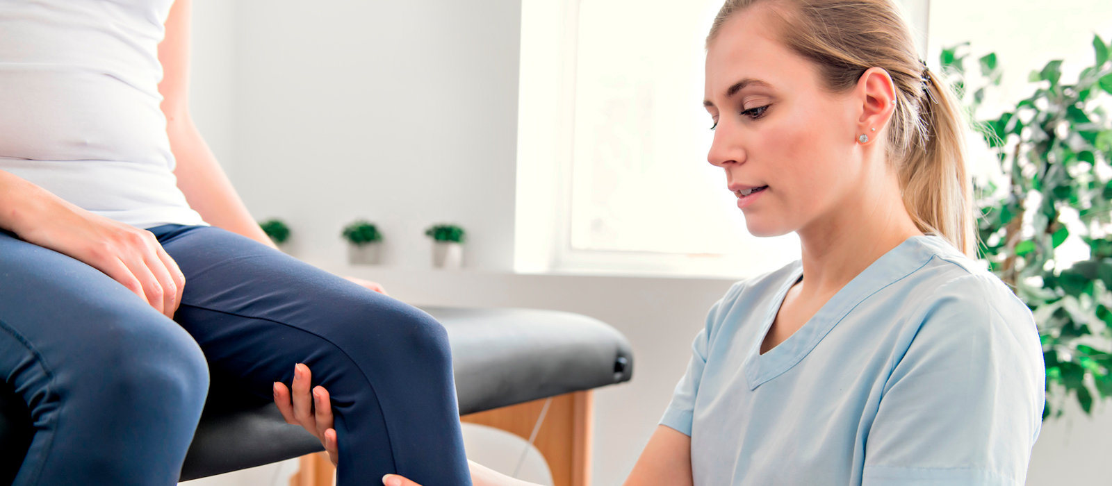 Physiotherapy and ergonomic solutions -woman physio inspecting patient knee