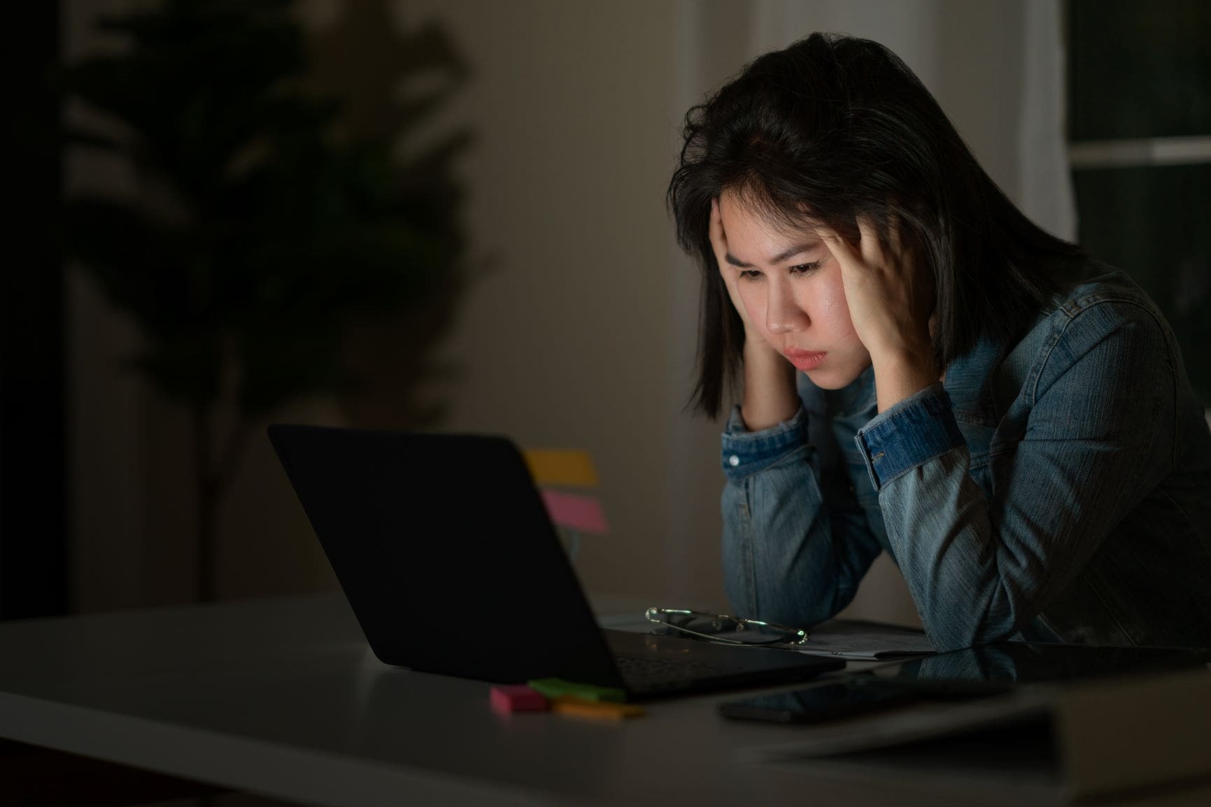 woman distressed looking at a laptop screen