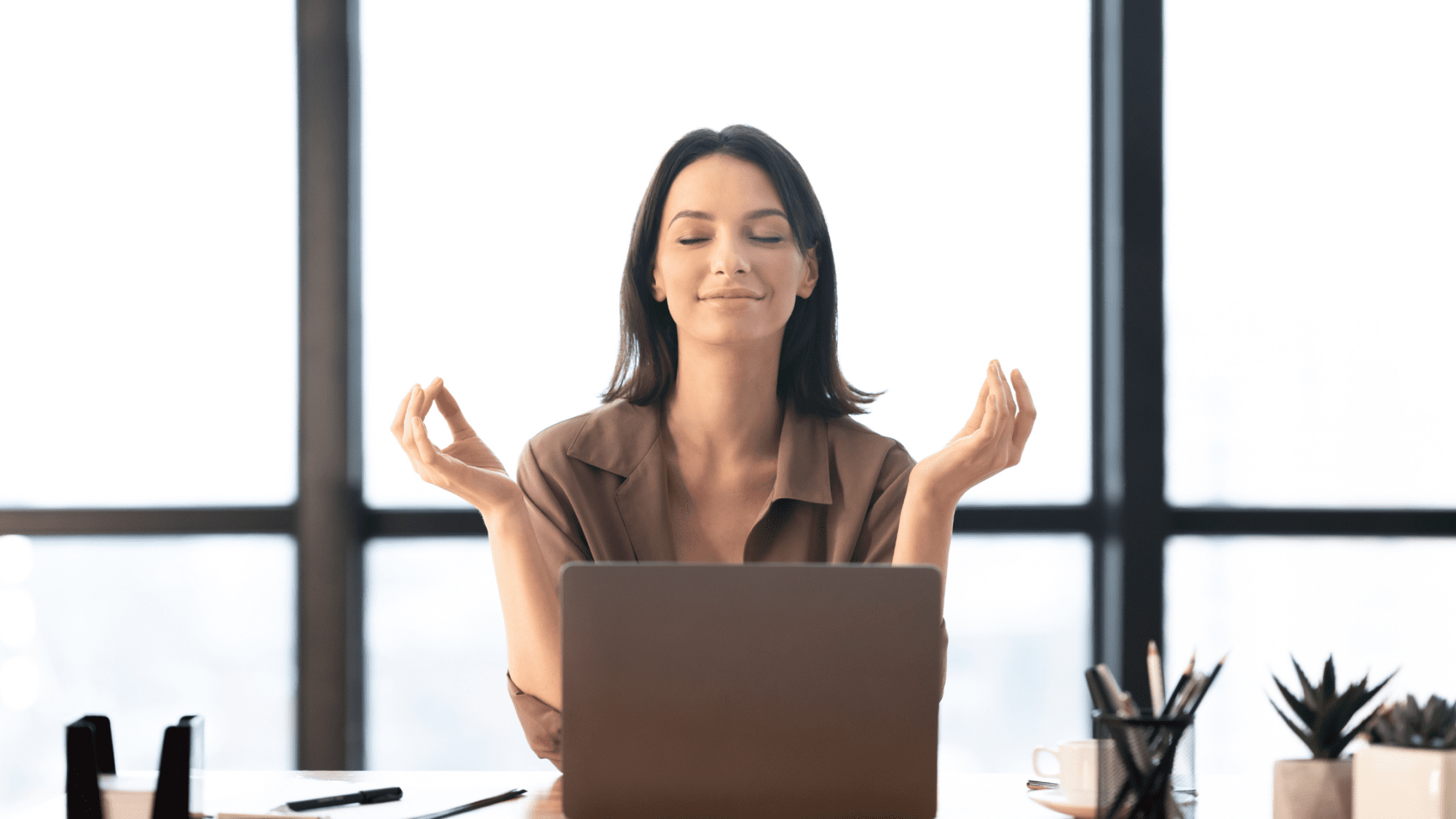 Woman coping with anxiety - sat at desk practicing mindfulness