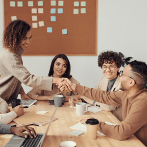 Group of young women and men in an office shaking hands