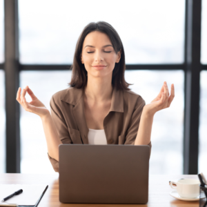 Women in an office doing a meditation pose 